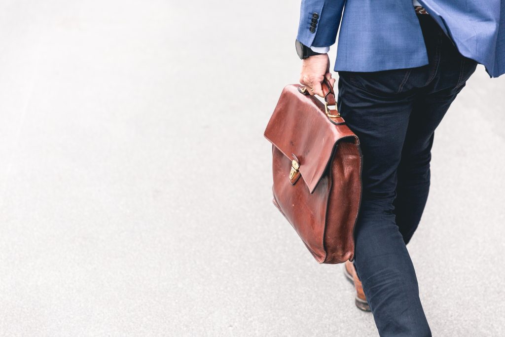 Uomo cammina con valigetta di lavoro