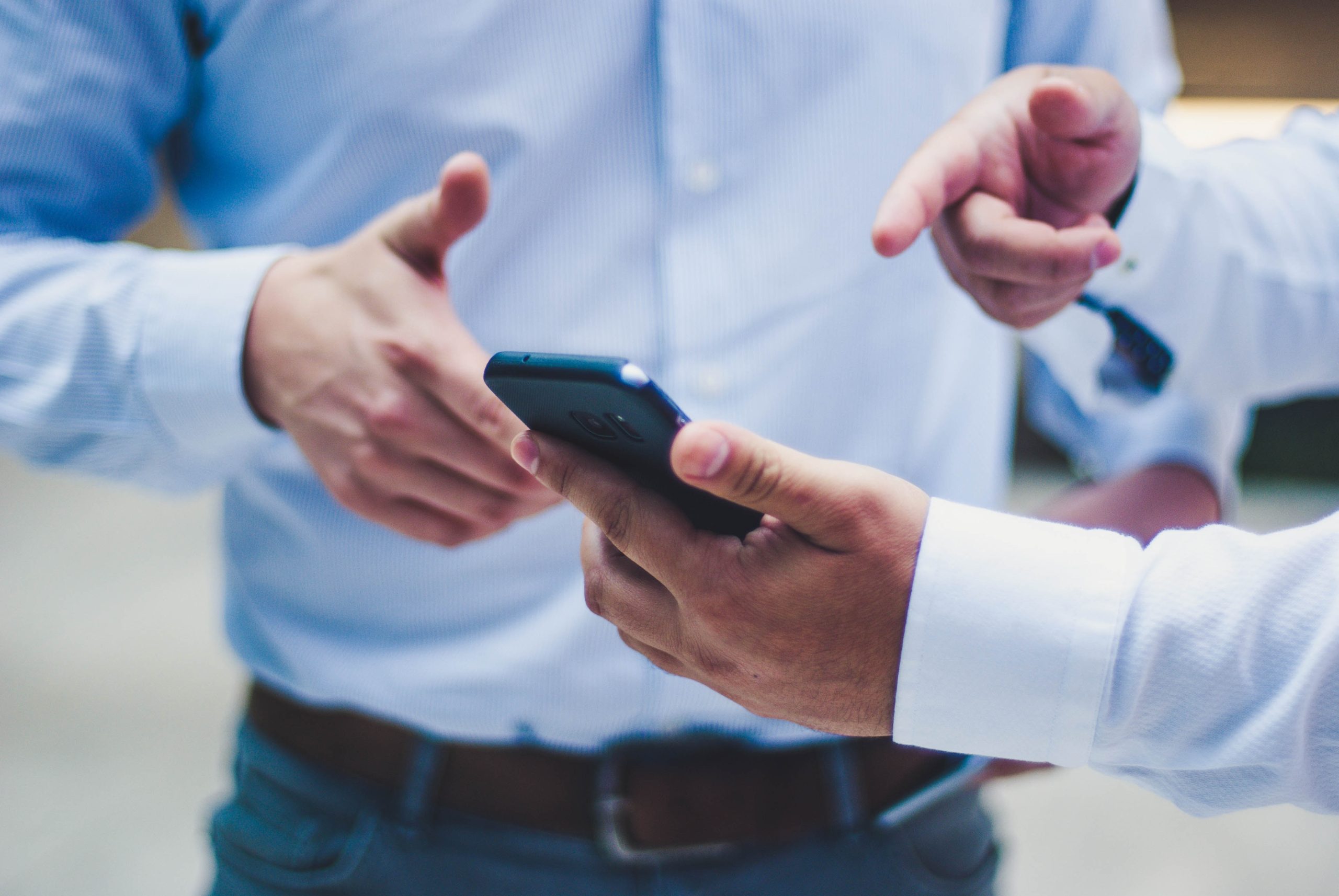 Uomini d'affari leggono e indicano uno smartphone
