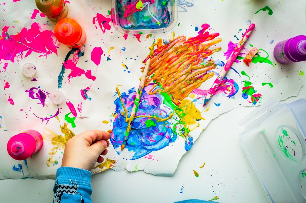 Bambino colora con i pennelli