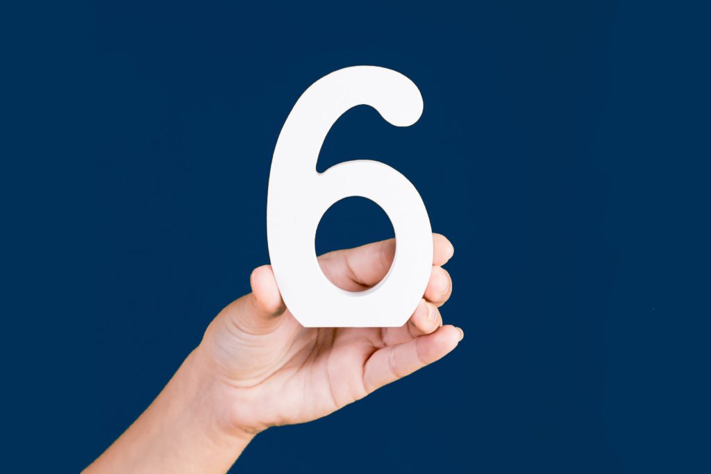 Numero 6 tenuto in mano da una persona