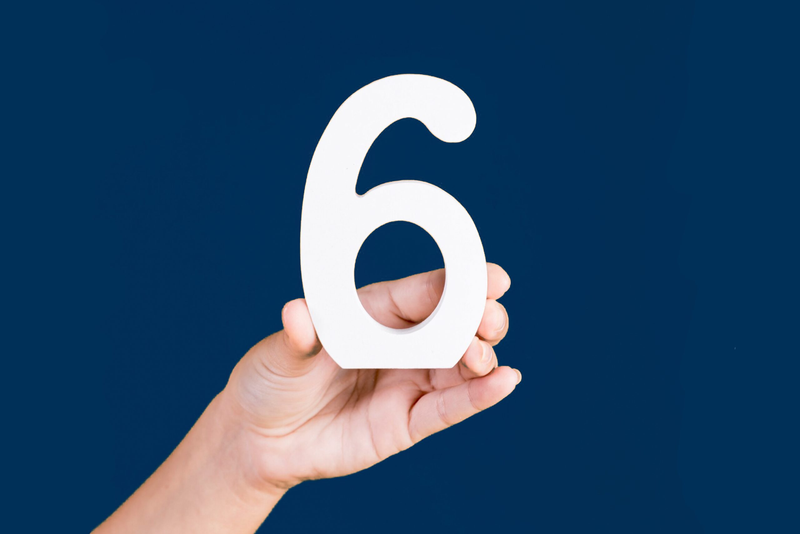 Numero 6 tenuto in mano da una persona