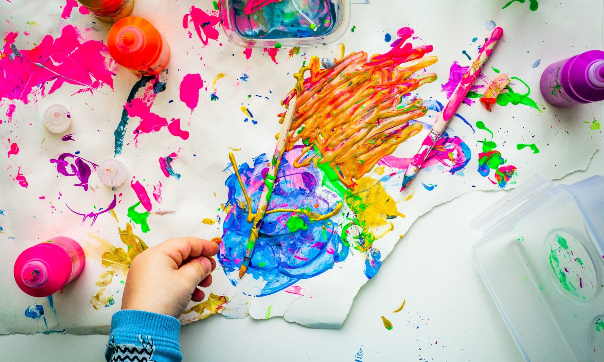 Bambino colora con i pennelli